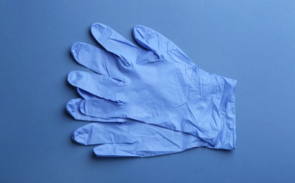Pair of medical gloves on blue background, flat lay Photo of Pair of medical gloves on blue background, flat lay