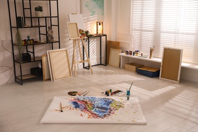 Wooden easel and abstract picture in art studio Photo of Wooden easel and abstract picture in art studio