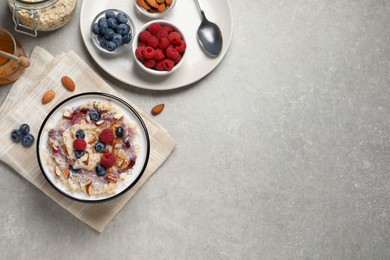 Tasty oatmeal porridge with toppings served on grey table, flat lay. Space for text Photo of Tasty oatmeal porridge with toppings served on grey table, flat lay. Space for text