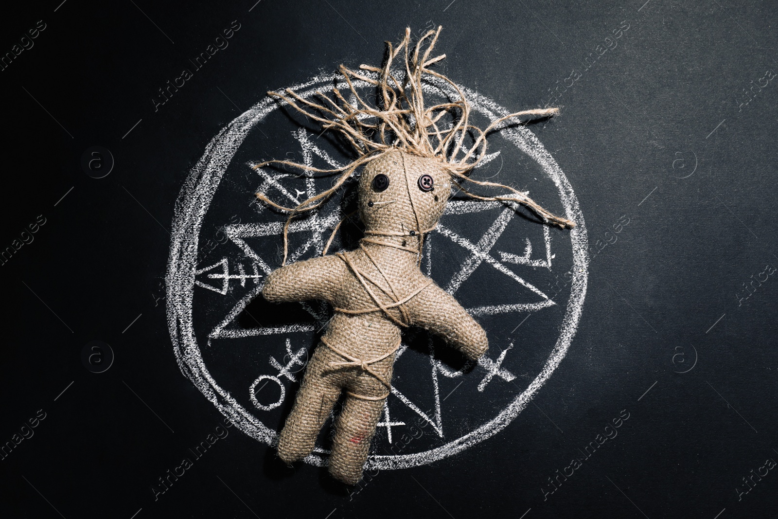 Female voodoo doll and runes on black background, top view Photo of Female voodoo doll and runes on black background, top view