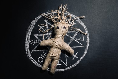 Female voodoo doll and runes on black background, top view Photo of Female voodoo doll and runes on black background, top view
