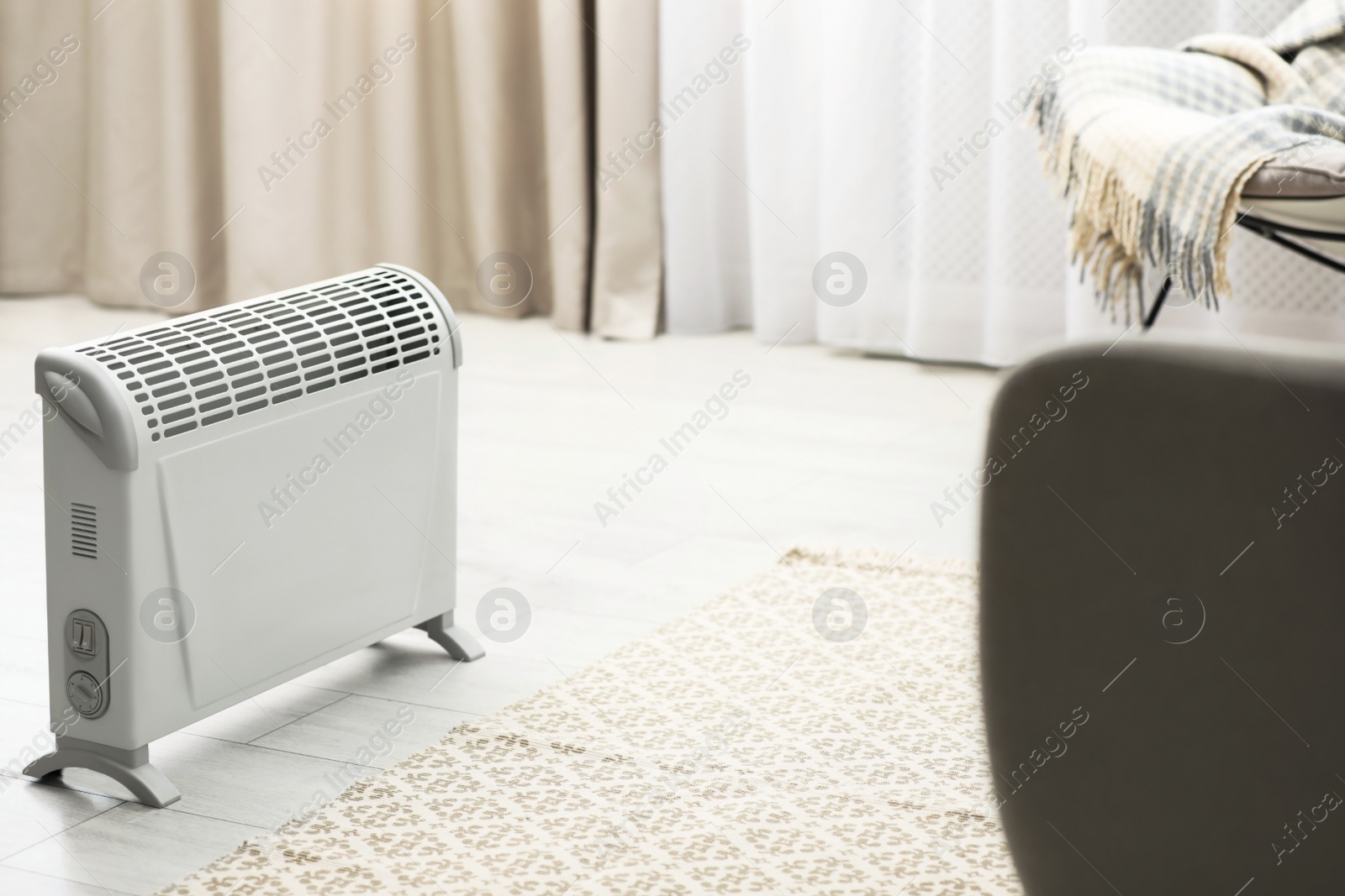 Modern electric heater in stylish room interior Image of Modern electric heater in stylish room interior