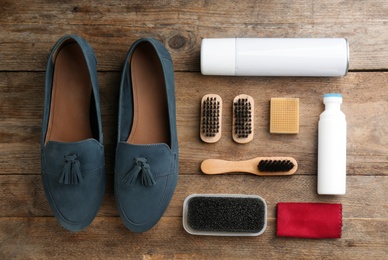Stylish footwear with shoe care accessories on wooden table, flat lay Photo of Stylish footwear with shoe care accessories on wooden table, flat lay