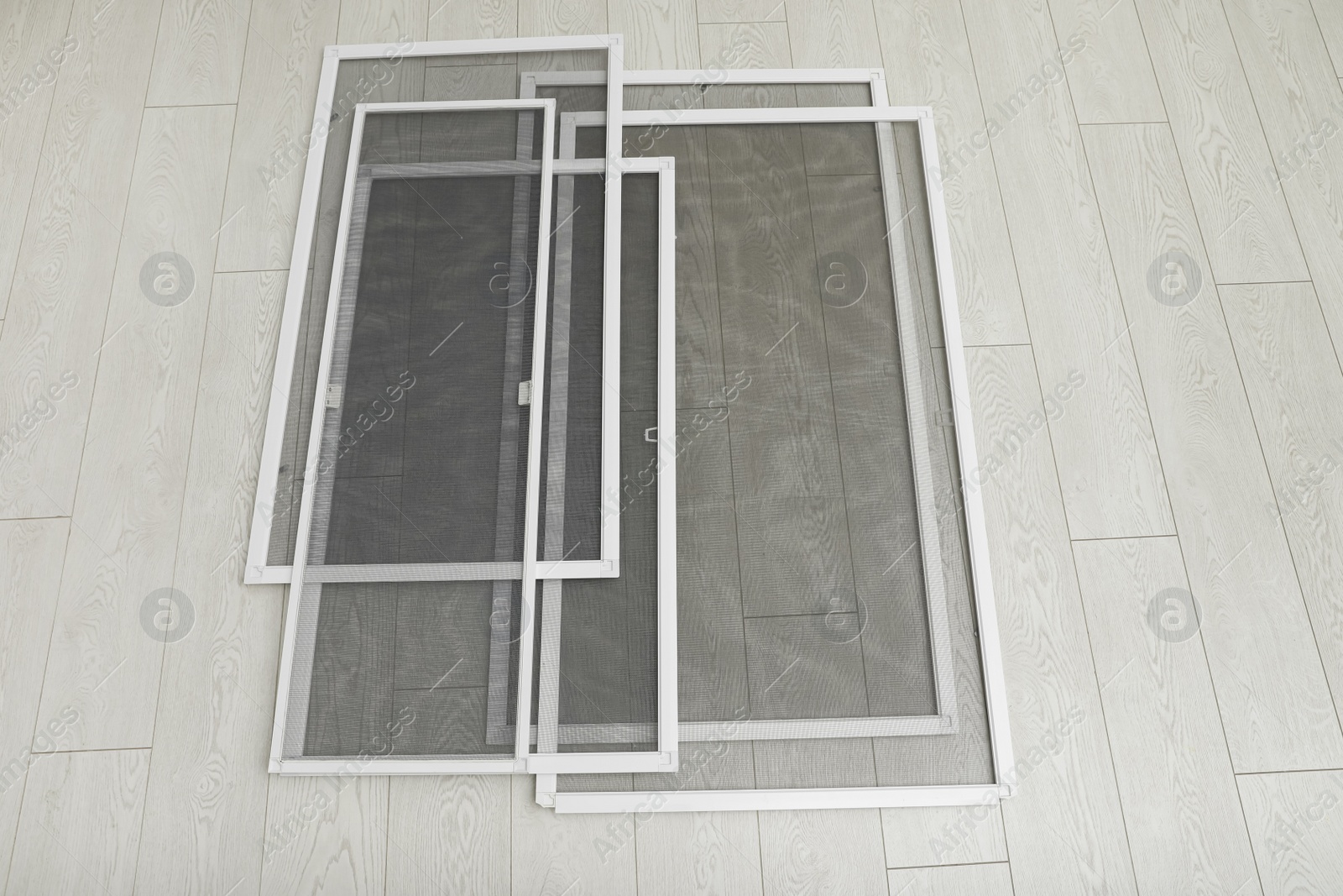 Photo of Set of window screens on wooden floor, above view