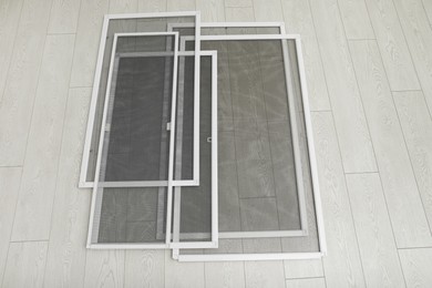 Set of window screens on wooden floor, above view Photo of Set of window screens on wooden floor, above view