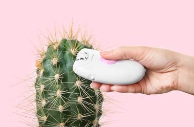 Hair removal concept. Cactus and woman holding epilator on pink background, closeup Image of Hair removal concept. Cactus and woman holding epilator on pink background, closeup