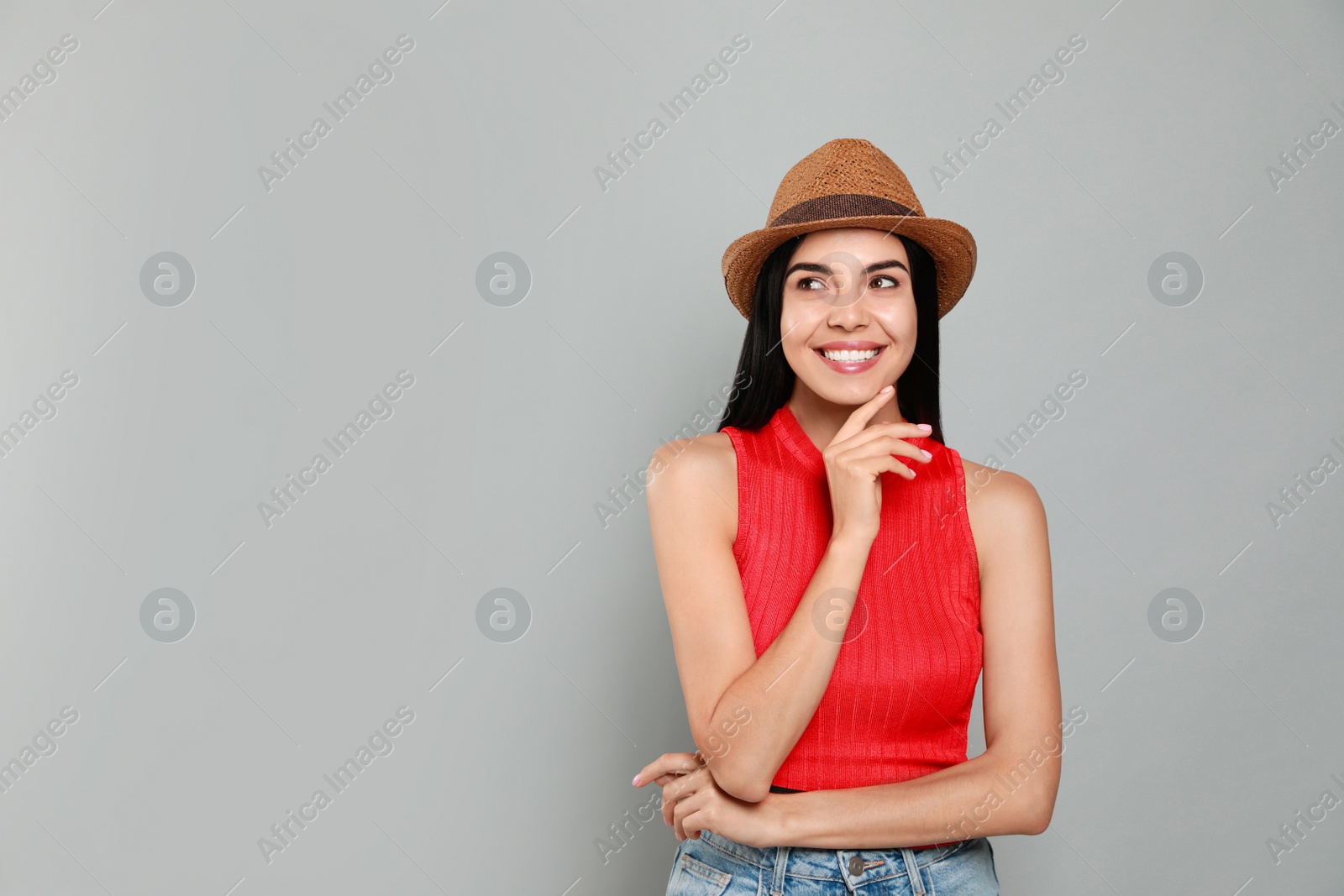 Beautiful young woman with straw hat on light grey background. Space for text Photo of Beautiful young woman with straw hat on light grey background. Space for text