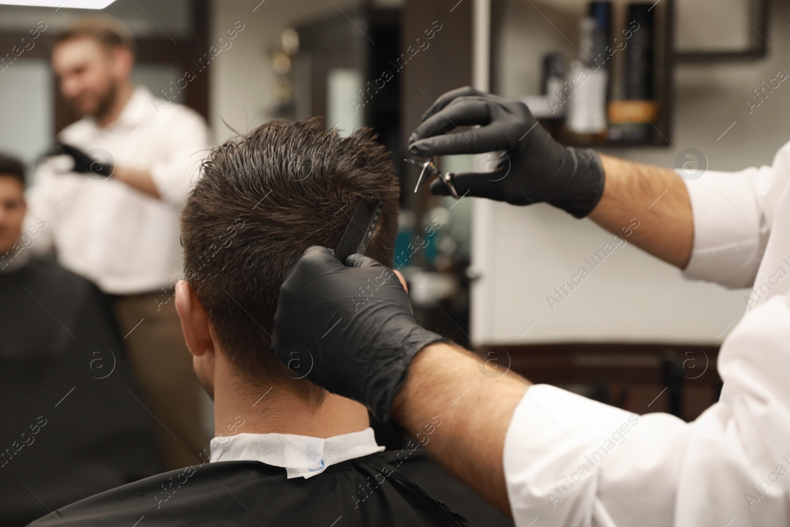 Professional hairdresser making stylish haircut in salon, closeup Photo of Professional hairdresser making stylish haircut in salon, closeup