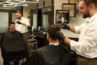 Professional hairdresser making stylish haircut in salon Photo of Professional hairdresser making stylish haircut in salon