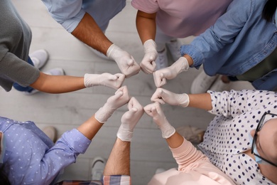 Group of people in white medical gloves showing thumbs up indoors, top view Photo of Group of people in white medical gloves showing thumbs up indoors, top view