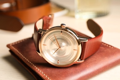 Luxury wrist watch and wallet on table, closeup Photo of Luxury wrist watch and wallet on table, closeup