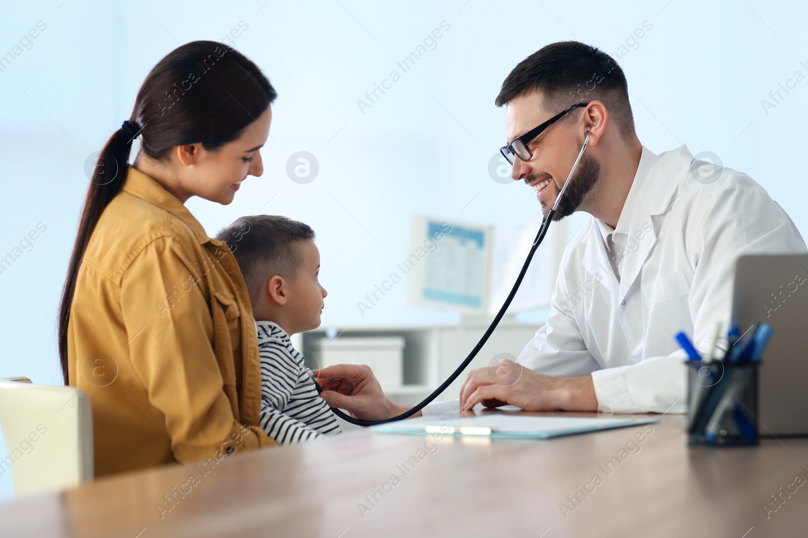 Mother and son visiting pediatrician in hospital. Doctor examining little boy Photo of Mother and son visiting pediatrician in hospital. Doctor examining little boy