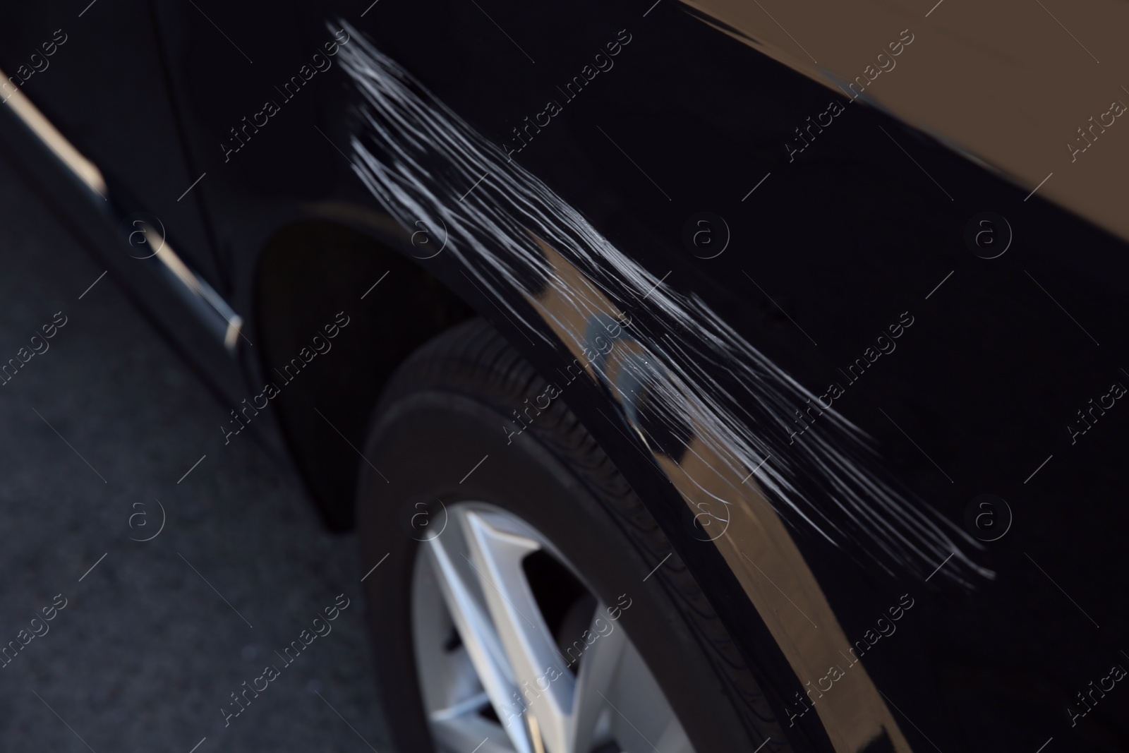 Modern black car with scratch outdoors, closeup Photo of Modern black car with scratch outdoors, closeup