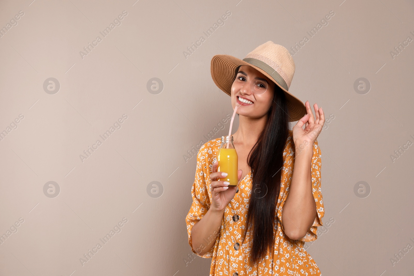 Beautiful young woman with straw hat and glass of refreshing drink on beige background. Space for text Photo of Beautiful young woman with straw hat and glass of refreshing drink on beige background. Space for text