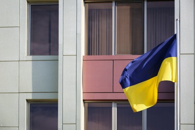 Ukrainian flag and modern building on background Photo of Ukrainian flag and modern building on background