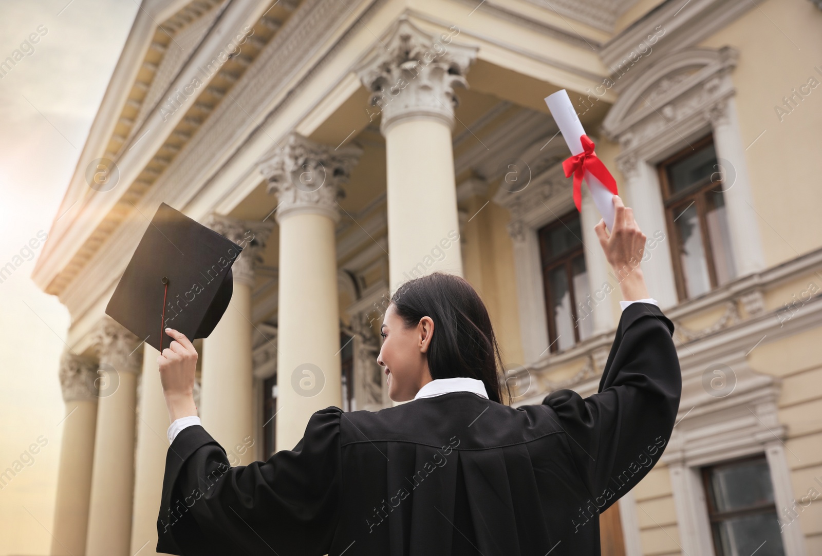 Student with diploma after graduation ceremony outdoors, low angle view Photo of Student with diploma after graduation ceremony outdoors, low angle view