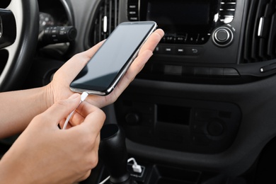 Person charging phone with USB cable in car Photo of Person charging phone with USB cable in car