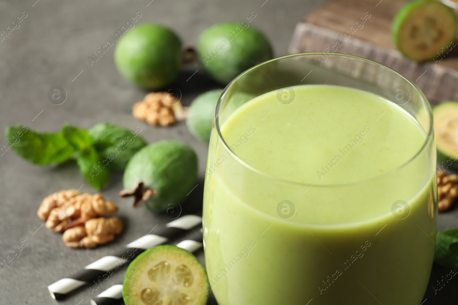 Fresh feijoa smoothie in glass on grey table, closeup with space for text Photo of Fresh feijoa smoothie in glass on grey table, closeup with space for text