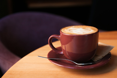 Photo of Aromatic coffee on wooden table in cafe. Space for text