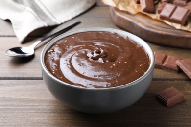 Delicious chocolate cream in bowl on wooden table Photo of Delicious chocolate cream in bowl on wooden table