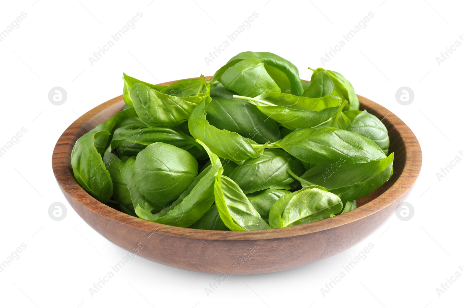 Fresh basil leaves in wooden bowl isolated on white Photo of Fresh basil leaves in wooden bowl isolated on white