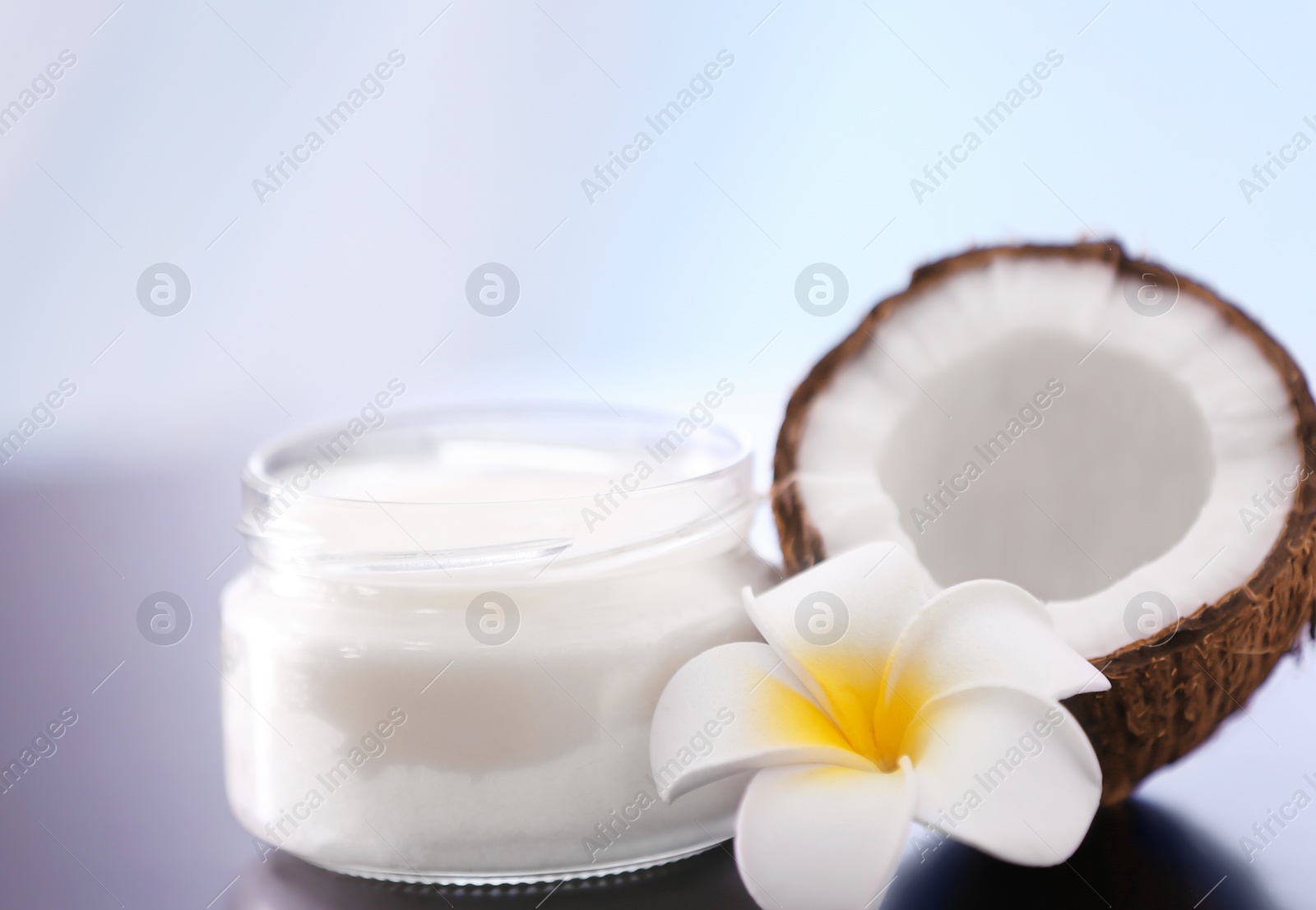 Composition with coconut butter in glass jar on blurred background Photo of Composition with coconut butter in glass jar on blurred background