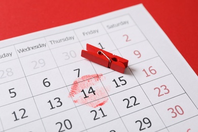 Calendar with marked Valentine's Day and clothespin on red background, closeup Photo of Calendar with marked Valentine's Day and clothespin on red background, closeup