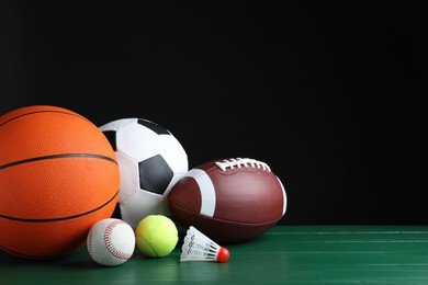 Set of different sport balls and shuttlecock on green wooden surface. Space for text Photo of Set of different sport balls and shuttlecock on green wooden surface. Space for text