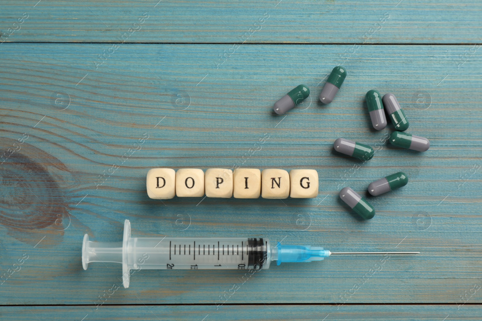 Cubes with word Doping and drugs on light blue wooden background, flat lay Photo of Cubes with word Doping and drugs on light blue wooden background, flat lay