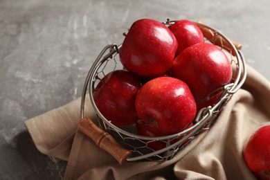 Basket with fresh ripe red apples on grey background Photo of Basket with fresh ripe red apples on grey background