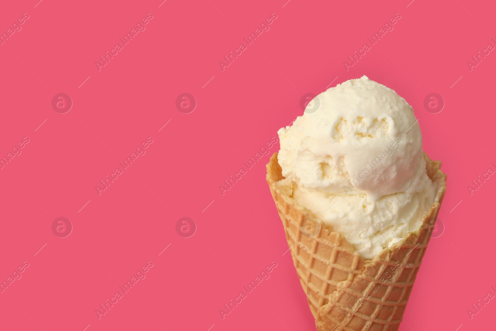 Delicious ice cream in waffle cone on pink background, closeup. Space for text Photo of Delicious ice cream in waffle cone on pink background, closeup. Space for text