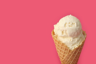 Delicious ice cream in waffle cone on pink background, closeup. Space for text Photo of Delicious ice cream in waffle cone on pink background, closeup. Space for text