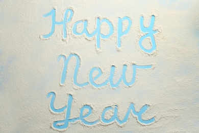 Phrase Happy New Year made of flour on light blue background, top view Photo of Phrase Happy New Year made of flour on light blue background, top view