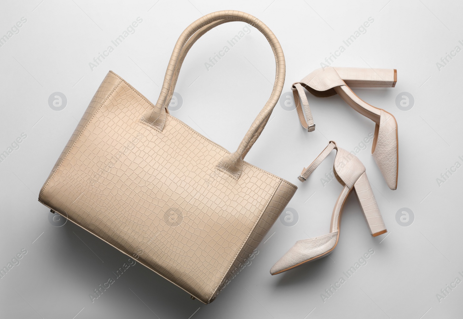 Stylish woman's bag and shoes on light background, flat lay Photo of Stylish woman's bag and shoes on light background, flat lay