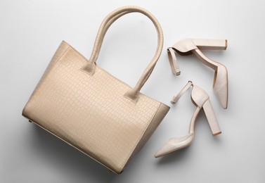 Stylish woman's bag and shoes on light background, flat lay Photo of Stylish woman's bag and shoes on light background, flat lay