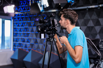 Professional video camera operator working in studio Photo of Professional video camera operator working in studio