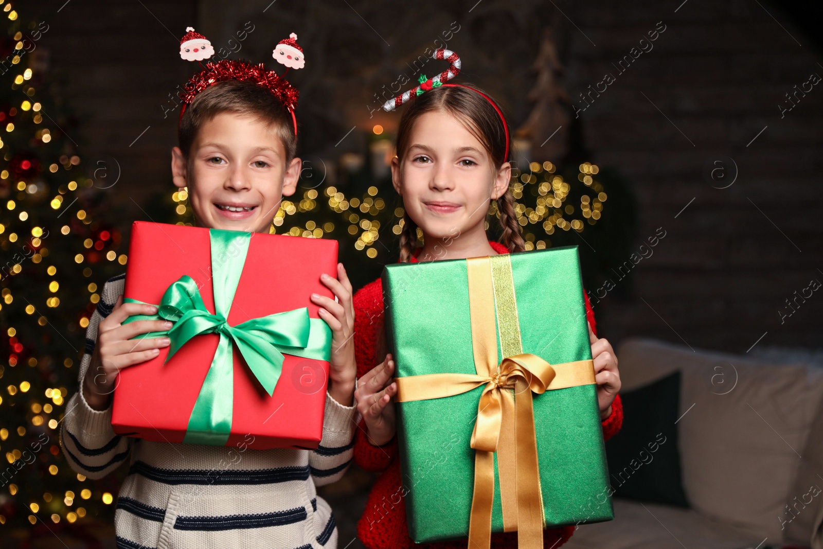 Portrait of happy children with Christmas gifts at home Photo of Portrait of happy children with Christmas gifts at home