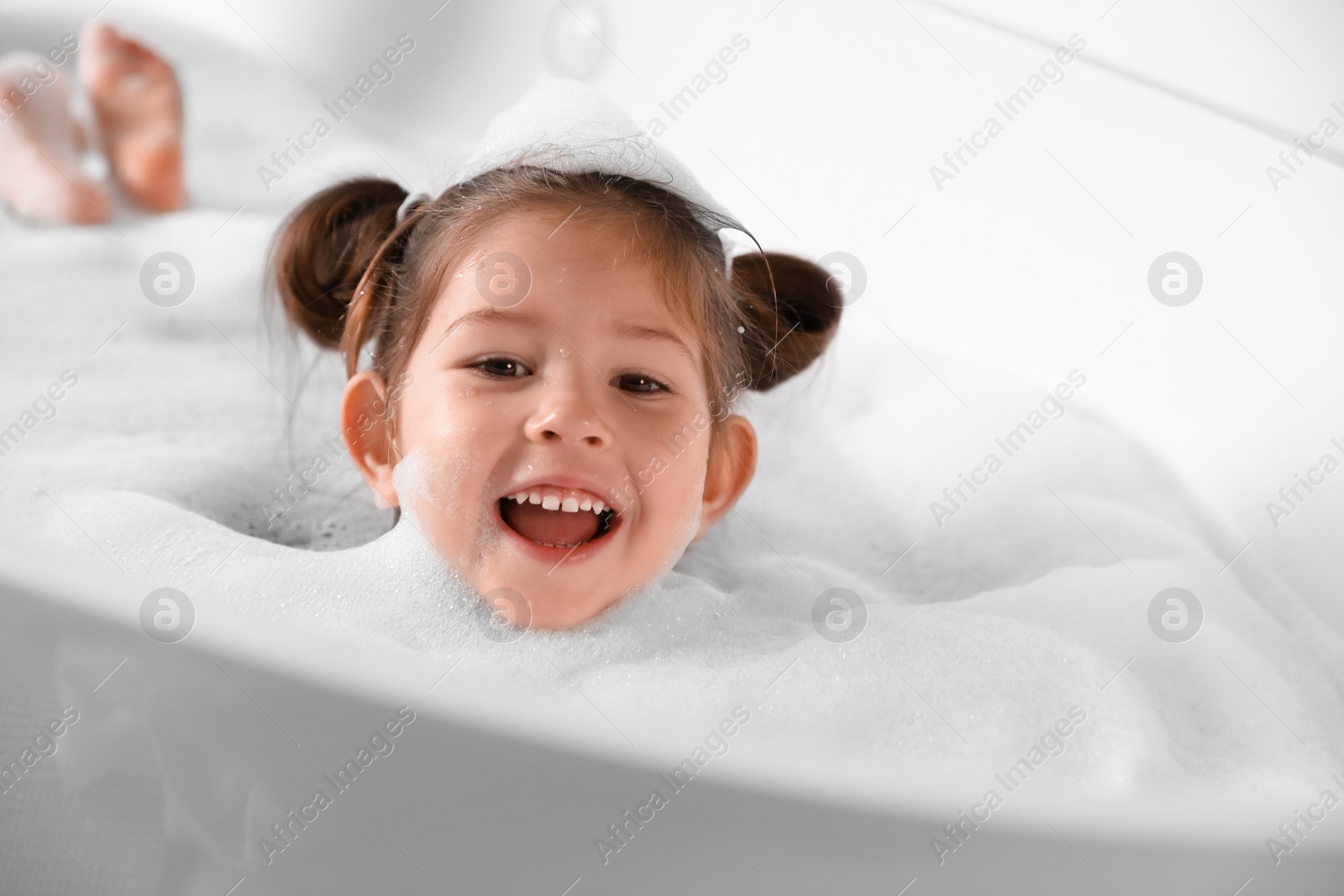 Cute little girl taking bubble bath at home Photo of Cute little girl taking bubble bath at home