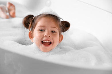 Cute little girl taking bubble bath at home Photo of Cute little girl taking bubble bath at home