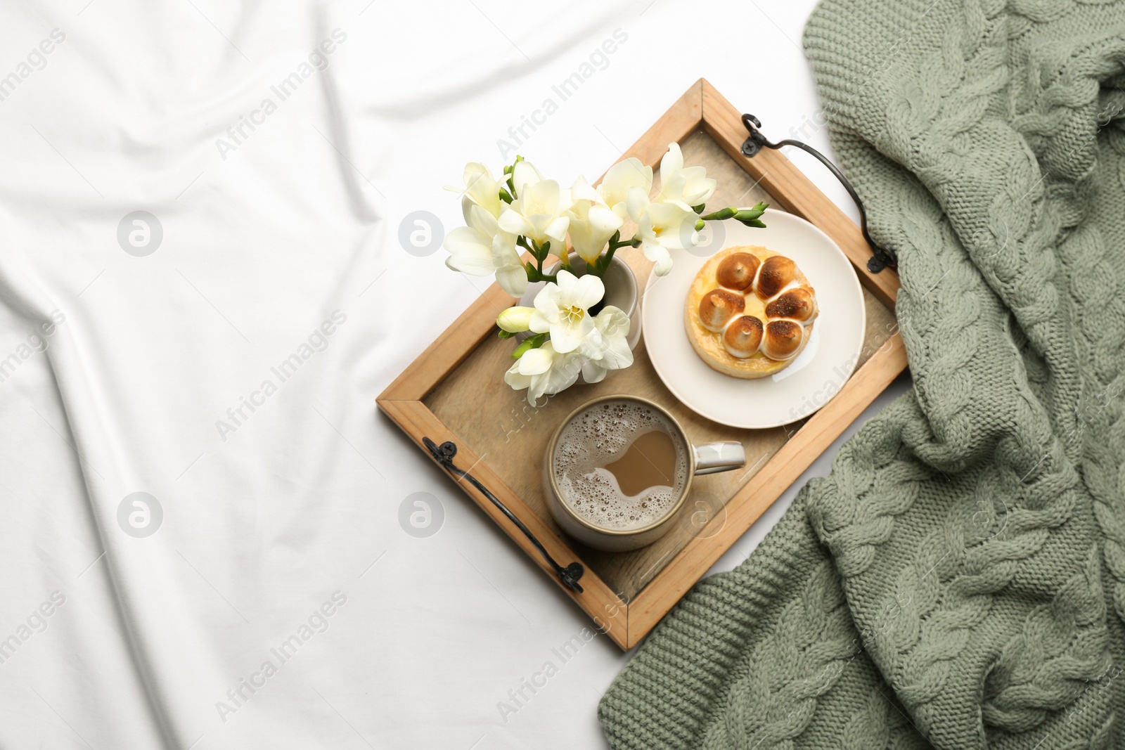 Flat lay composition with coffee and warm plaid on white bedsheet Photo of Flat lay composition with coffee and warm plaid on white bedsheet