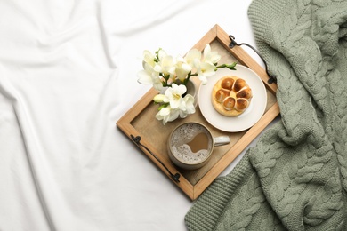 Flat lay composition with coffee and warm plaid on white bedsheet Photo of Flat lay composition with coffee and warm plaid on white bedsheet