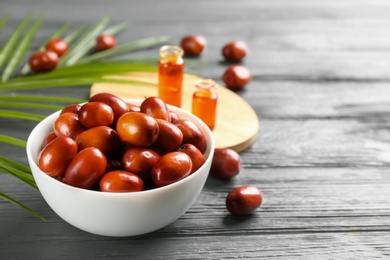 Palm oil fruits in bowl on grey wooden table, closeup Photo of Palm oil fruits in bowl on grey wooden table, closeup
