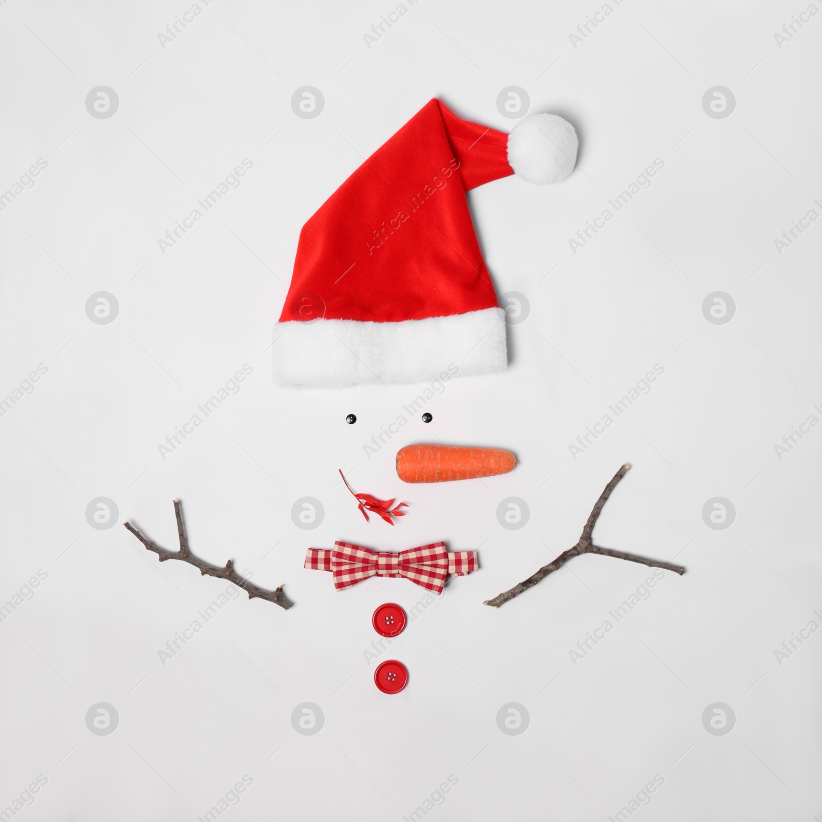 Creative snowman shape made of Santa hat and different items on white background, flat lay Photo of Creative snowman shape made of Santa hat and different items on white background, flat lay