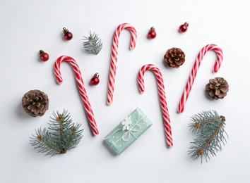 Flat lay composition with candy canes and Christmas decor on white background Photo of Flat lay composition with candy canes and Christmas decor on white background