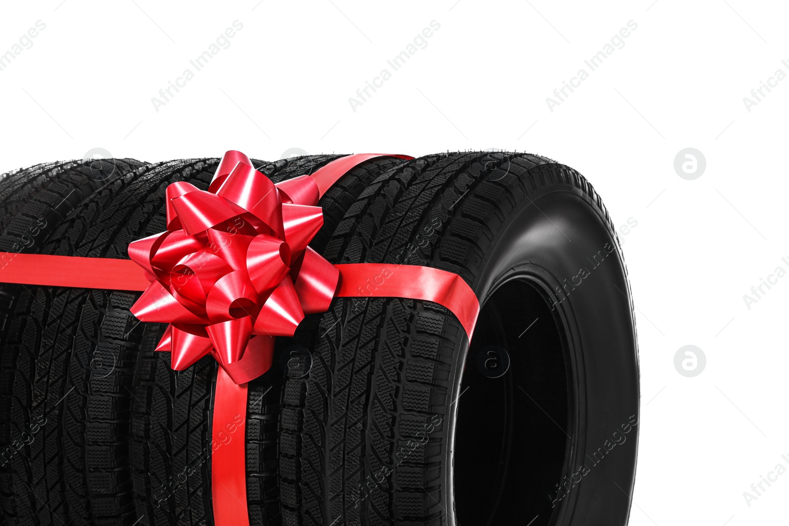 Winter tires with red ribbon on white background, closeup Photo of Winter tires with red ribbon on white background, closeup