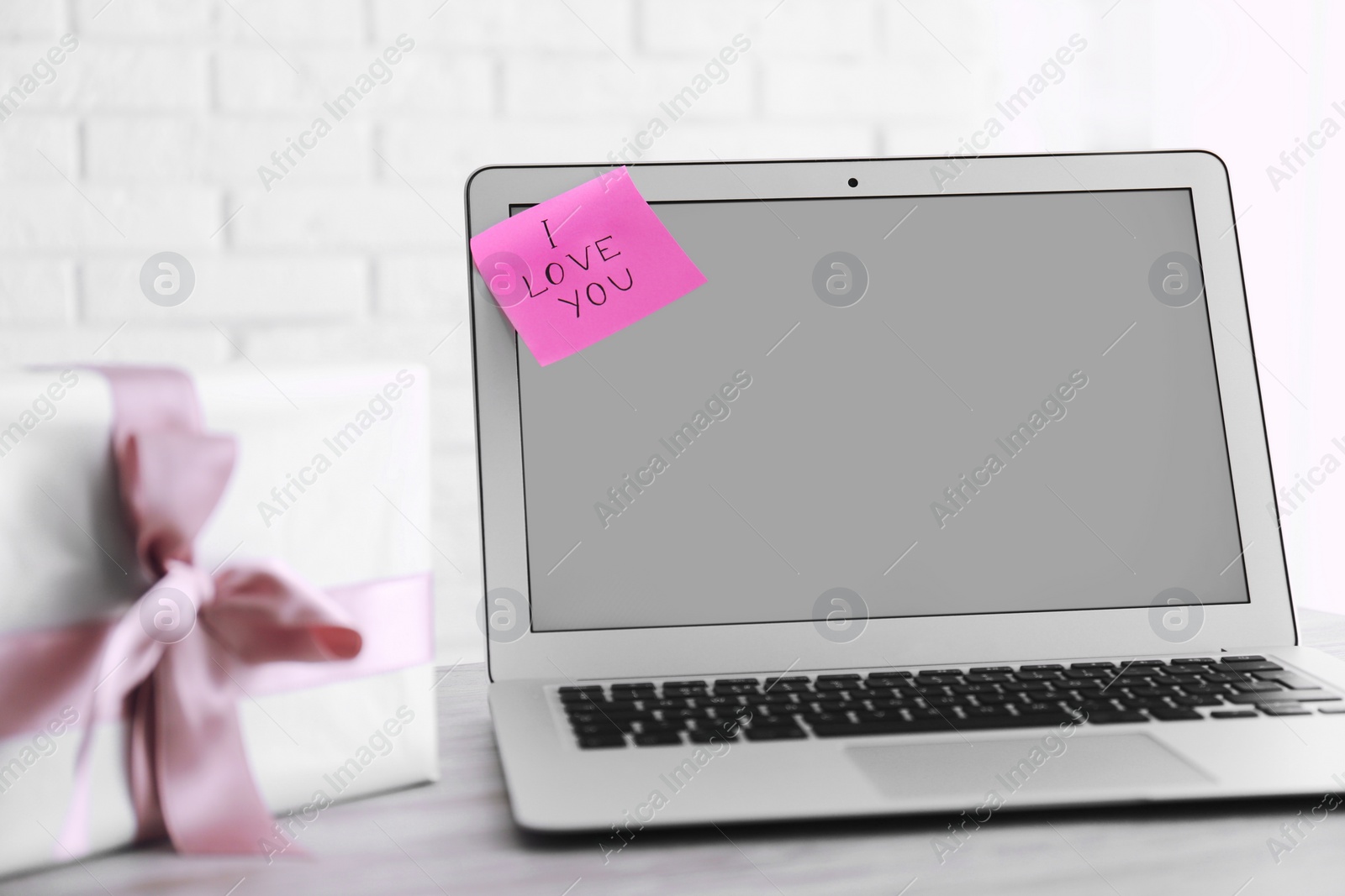 Memory sticker with phrase I Love You on laptop at table. Valentine's Day celebration Photo of Memory sticker with phrase I Love You on laptop at table. Valentine's Day celebration