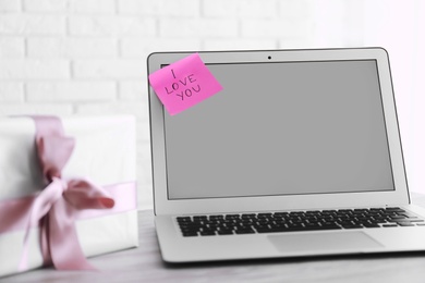 Memory sticker with phrase I Love You on laptop at table. Valentine's Day celebration Photo of Memory sticker with phrase I Love You on laptop at table. Valentine's Day celebration