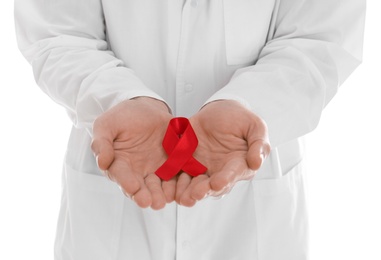 Doctor holding red awareness ribbon on white background, closeup. World AIDS disease day Photo of Doctor holding red awareness ribbon on white background, closeup. World AIDS disease day