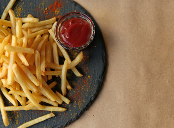 Tasty French fries with red sauce served on table in cafe, top view. Space for text Photo of Tasty French fries with red sauce served on table in cafe, top view. Space for text