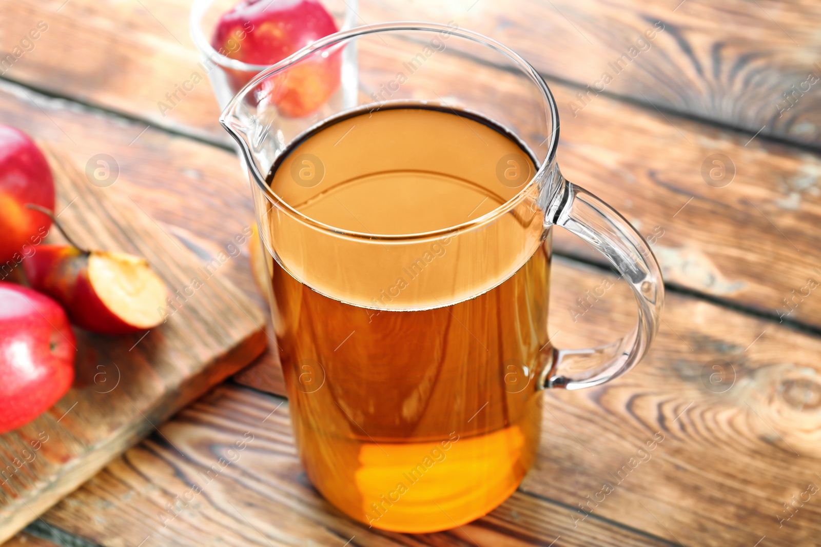 Jug with fresh apple juice on wooden table Photo of Jug with fresh apple juice on wooden table